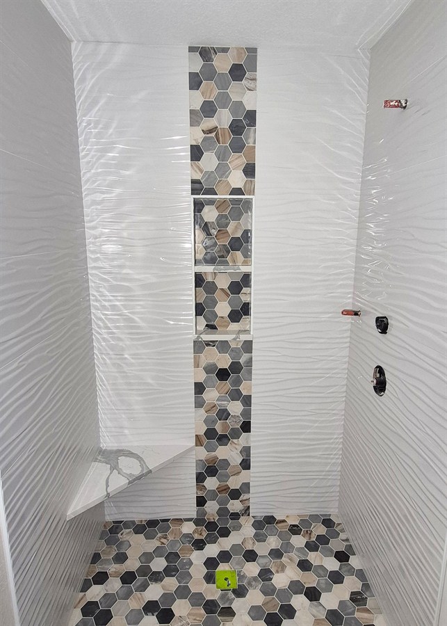 Hexagon marble mosaic tile shower with vertical accent strip
